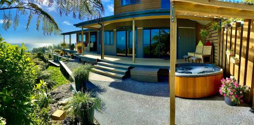 a house with a hot tub on the side of it at Tasman Sea Retreat in Punakaiki