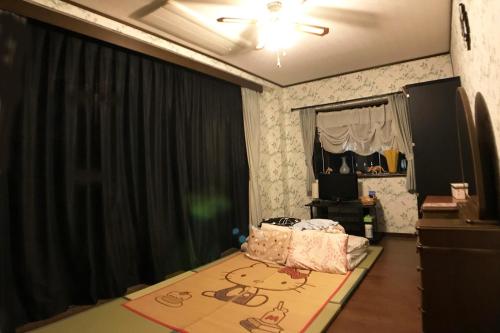 a bedroom with a black curtain and a bed with a rug at Nakagawa's Cozy House in Sakai