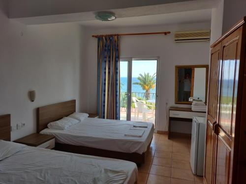 a hotel room with two beds and a view of the ocean at Afroditi Beach in Gerakini