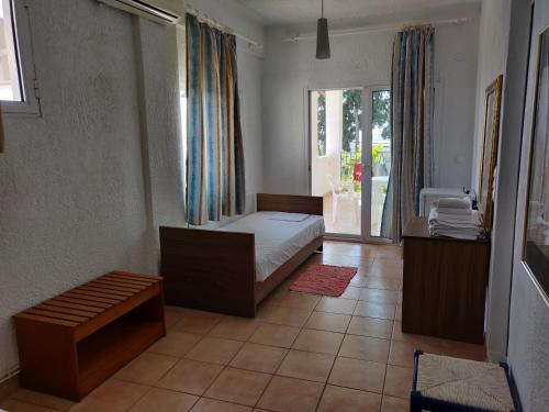 a bedroom with a bed and a large window at Afroditi Beach in Gerakini