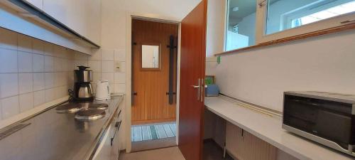 eine Küche mit zwei Waschbecken und einer Holztür in der Unterkunft Apartment Bad Mitterndorf/Steiermark 432 in Bad Mitterndorf