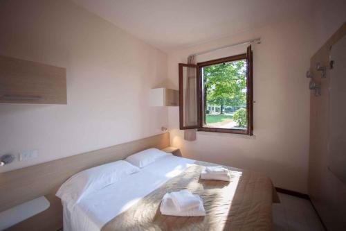 una camera da letto con un letto e due asciugamani di Holiday Homes in Sirmione/Gardasee 22174 a Sirmione