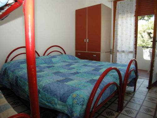 een slaapkamer met een bed met een blauwe quilt bij Apartments in Rosolina Mare 24945 in Rosolina Mare