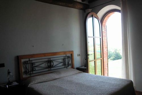 a bedroom with a bed and a large window at Apartments in Asciano/Toskana 24096 in Serre di Rapolano