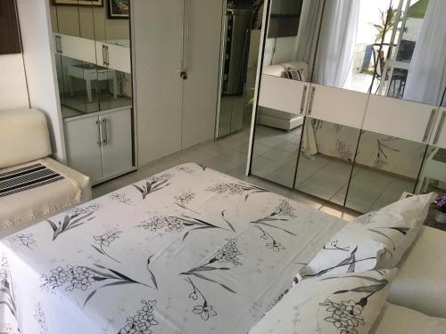 1 dormitorio con cama y espejo en Suite Golden Beach Frente Mar, en Recife