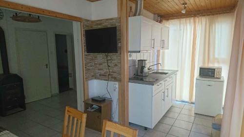 eine Küche mit weißen Schränken und einer Mikrowelle in der Unterkunft Holiday home in Balatonmariafürdo 31229 in Balatonmáriafürdő