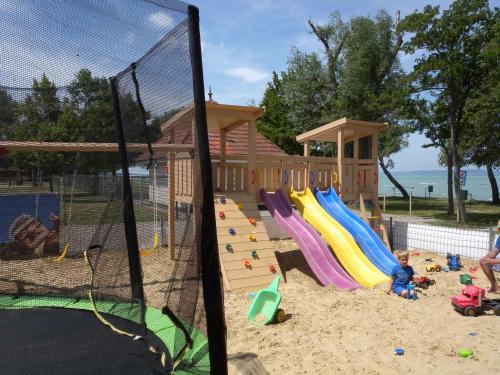 um parque infantil com uma estrutura de brincar e escorregas na areia em Studio in Siofok/Balaton 27759 em Siófok