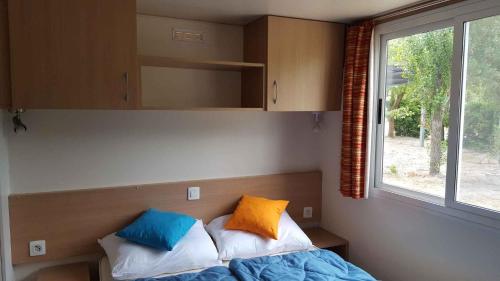 ein Schlafzimmer mit einem Bett mit zwei Kissen darauf in der Unterkunft Mobilehomes in Rosolina Mare 33791 in Rosolina Mare