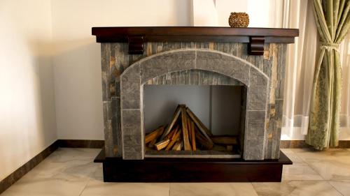 a stone fireplace in a living room at Hotel El Jerarca in Filandia