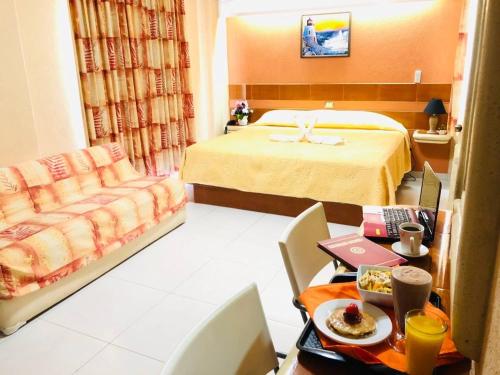 a hotel room with a bed and a table with food at Hotel San Angel Cerca Del Acuario in Veracruz