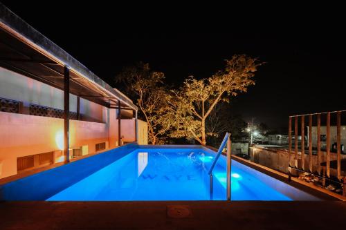 a swimming pool lit up at night at Waye Valladolid Centro - Sustainable, Authentic Experiences & Pet Friendly Boutique Hotel in Valladolid