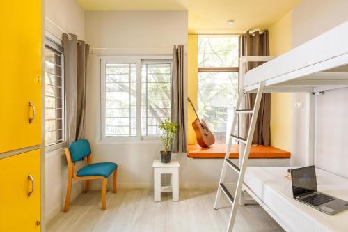 a bedroom with a bunk bed and a desk and a chair at Locul Central - Church Street in Bengaluru