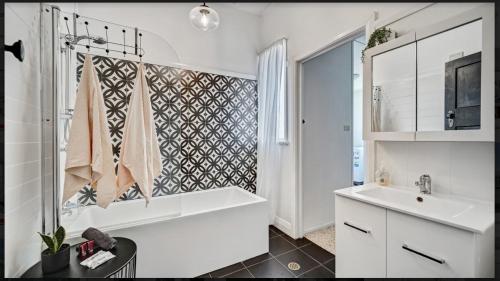 a white bathroom with a tub and a sink at "Donnelly House" in Tenterfield