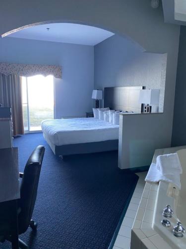 a blue room with a bed and a chair in it at Lakeside Resort & Conference Center in Houghton Lake