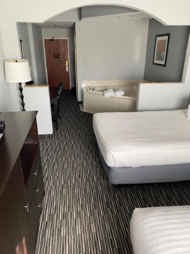 a hotel room with two beds and a desk at Lakeside Resort & Conference Center in Houghton Lake