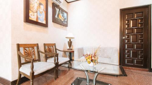 een woonkamer met een glazen tafel en stoelen bij RedDoorz Plus at Canley Residential in Manilla