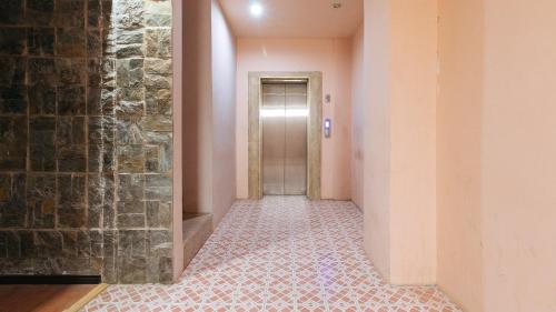 a hallway with a door and a brick wall at RedDoorz Plus at Canley Residential in Manila