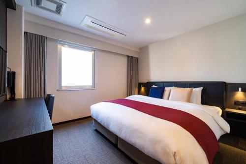 a hotel room with a large bed and a window at Hotel Shuranza Chiba in Chiba