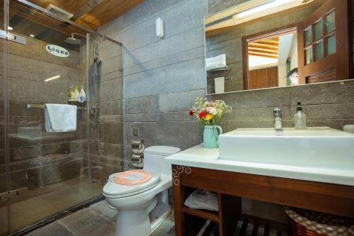 a bathroom with a sink and a toilet and a shower at 丽江束河元年别院 Yuannian Lijiang in Lijiang