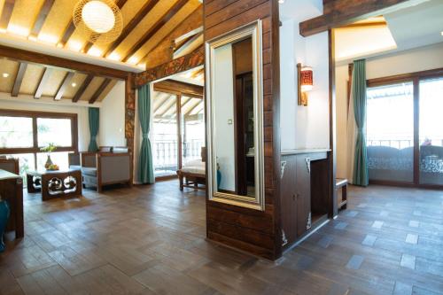 a living room with wooden floors and a large room withwindows at 丽江束河元年别院 Yuannian Lijiang in Lijiang