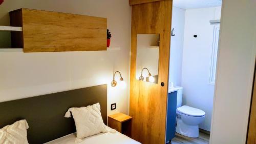 Dormitorio pequeño con cama y aseo en Mobile home De Luxe St Cyprien, en Saint-Cyprien