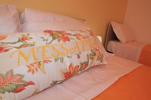 a bed with aspread with the word mesasy on it at Messapia Casa Vacanze in Ugento
