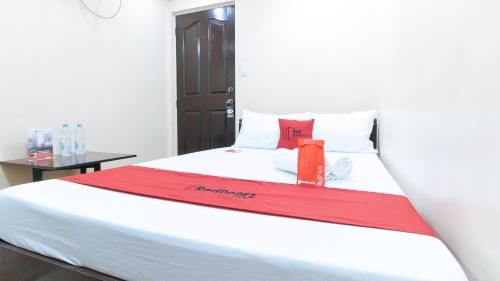 a bed with a red blanket on top of it at RedDoorz Plus at Canley Residential in Manila