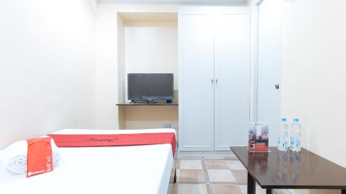 a living room with a table and a tv at RedDoorz Plus at Canley Residential in Manila