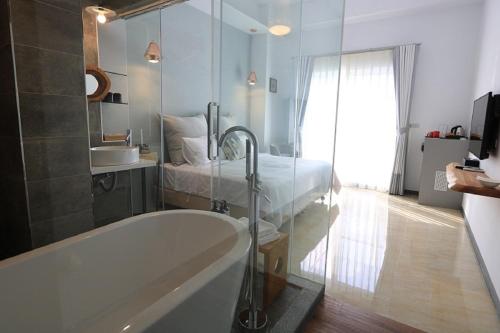 a bathroom with a bath tub and a bed at La Fleur BnB & Restaurant in Hengchun