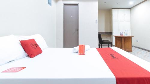 a bedroom with a large white bed with red pillows at RedDoorz Plus at Canley Residential in Manila