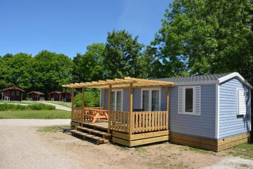 uma pequena cabina com um alpendre e um deque em Jelling Family Camping & Cottages em Jelling