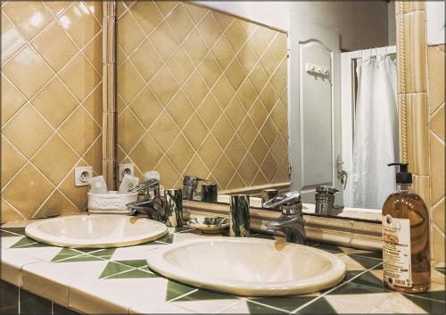 une salle de bain avec deux lavabos et un grand miroir dans l'établissement Ecuries Sainte Croix, à Carcassonne