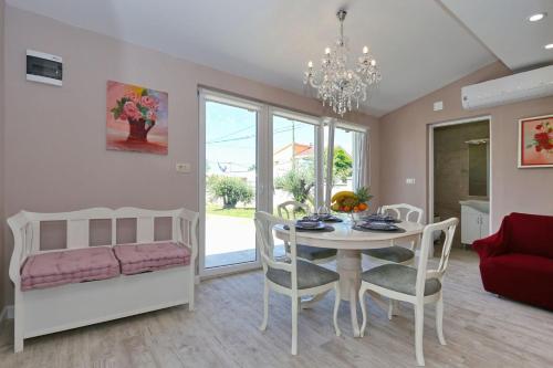 a dining room and living room with a table and chairs at HACIENDA MIA with yacuzzi,BBQ , free parking in Zadar