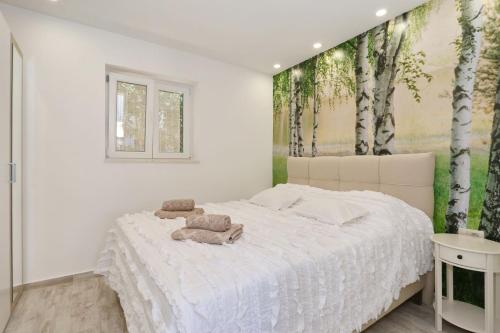 ein Schlafzimmer mit einem weißen Bett mit zwei Handtüchern darauf in der Unterkunft HACIENDA MIA extra in Zadar