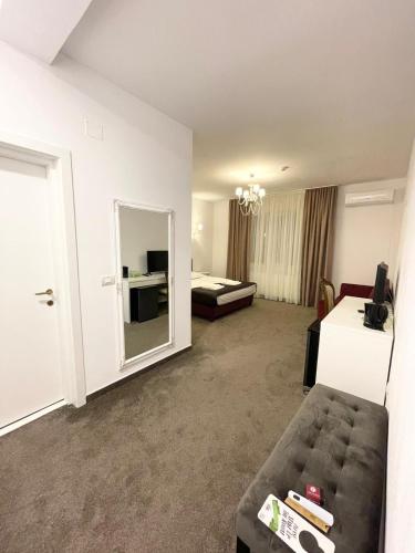 a hotel room with a couch and a bedroom at COCHET BOUTIQUE in Târgu Jiu