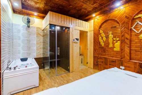 uma casa de banho com chuveiro e uma cama num quarto em TheKing Hotel em Hương Gia