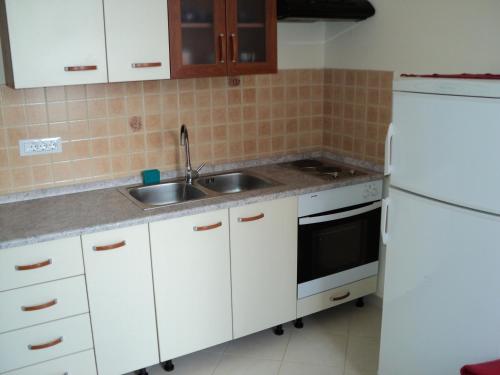 una cocina con armarios blancos y fregadero en Apartment Mandrač, en Novigrad Istria