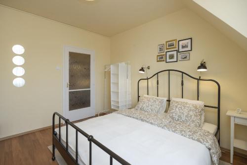 a bedroom with a large bed with white sheets at Hősök Apartman in Eger