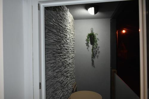 a hallway with a stone wall and a plant on the wall at WooW Apartments in Velika Gorica