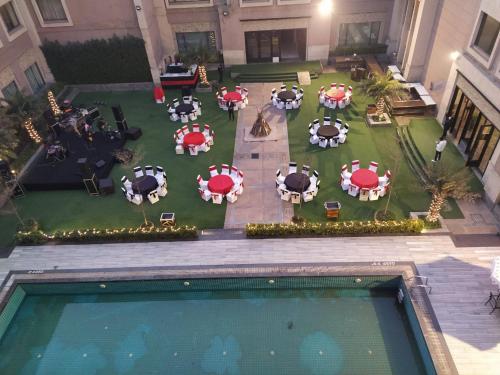 an overhead view of a patio with tables and umbrellas at Tivoli Garden Resort in New Delhi