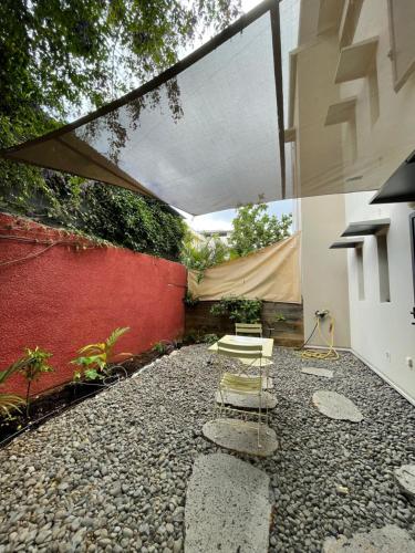 a patio with a white table and a tent at 100 rue Suffren in Saint-Pierre