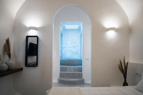 a hallway with a stairway leading to a blue window at Terra e Lavoro Luxury Suite in Éxo Goniá