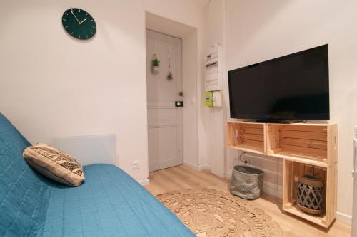 a living room with a blue couch and a flat screen tv at Au coeur de Sanary-sur-Mer studio cosy in Sanary-sur-Mer