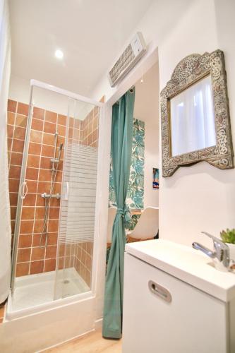 une salle de bain avec une douche, un lavabo et un miroir dans l'établissement Au coeur de Sanary-sur-Mer studio cosy, à Sanary-sur-Mer
