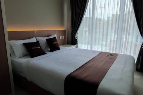 a large bed in a hotel room with a large window at Shakilla House 1A Syariah in Cianjur