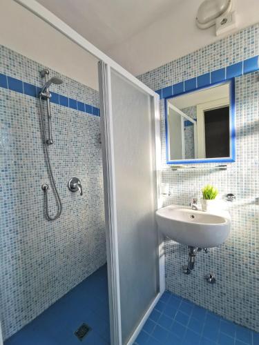 a blue tiled bathroom with a sink and a shower at Hotel Bellini in Riccione