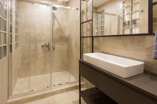 a bathroom with a sink and a shower at Hotel @Syngrou Fix in Athens