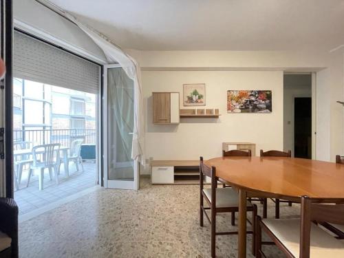 une salle à manger avec une table et un balcon dans l'établissement RESIDENCE CENTRO COMMERCIALE - WALTERIGATO Apartments SOLO PER FAMIGLIE, à Lido di Jesolo