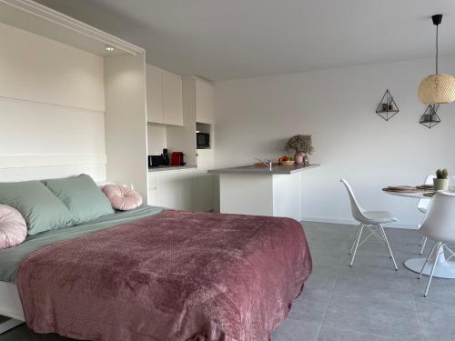 um quarto com uma cama, uma mesa e cadeiras em Beau séjour em Bredene