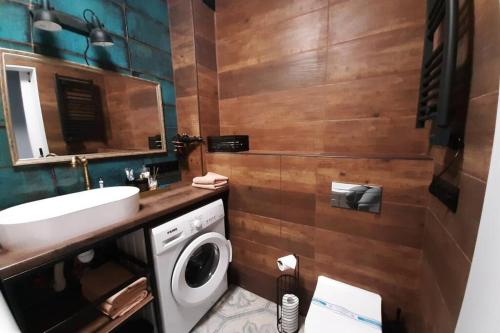 łazienka z umywalką i pralką w obiekcie Relax Point Plus Apartment w mieście Irpień